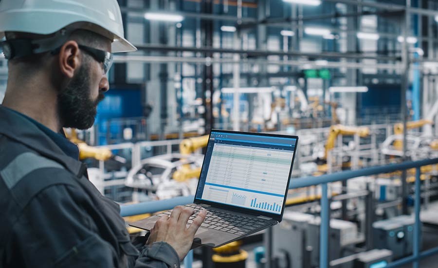 A person in a hard hat is using a computer