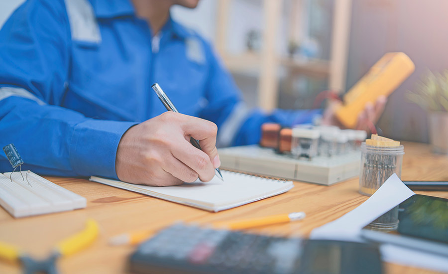 A person writing on a notebook​